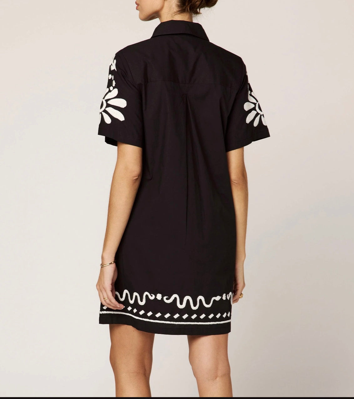 The Riya Mini Dress features a relaxed, button-down silhouette with short sleeves