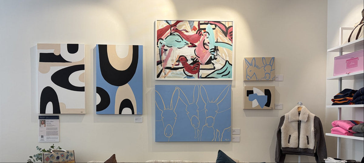 Mary Ellen Harney's paintings on the wall at Happy on Main West Concord