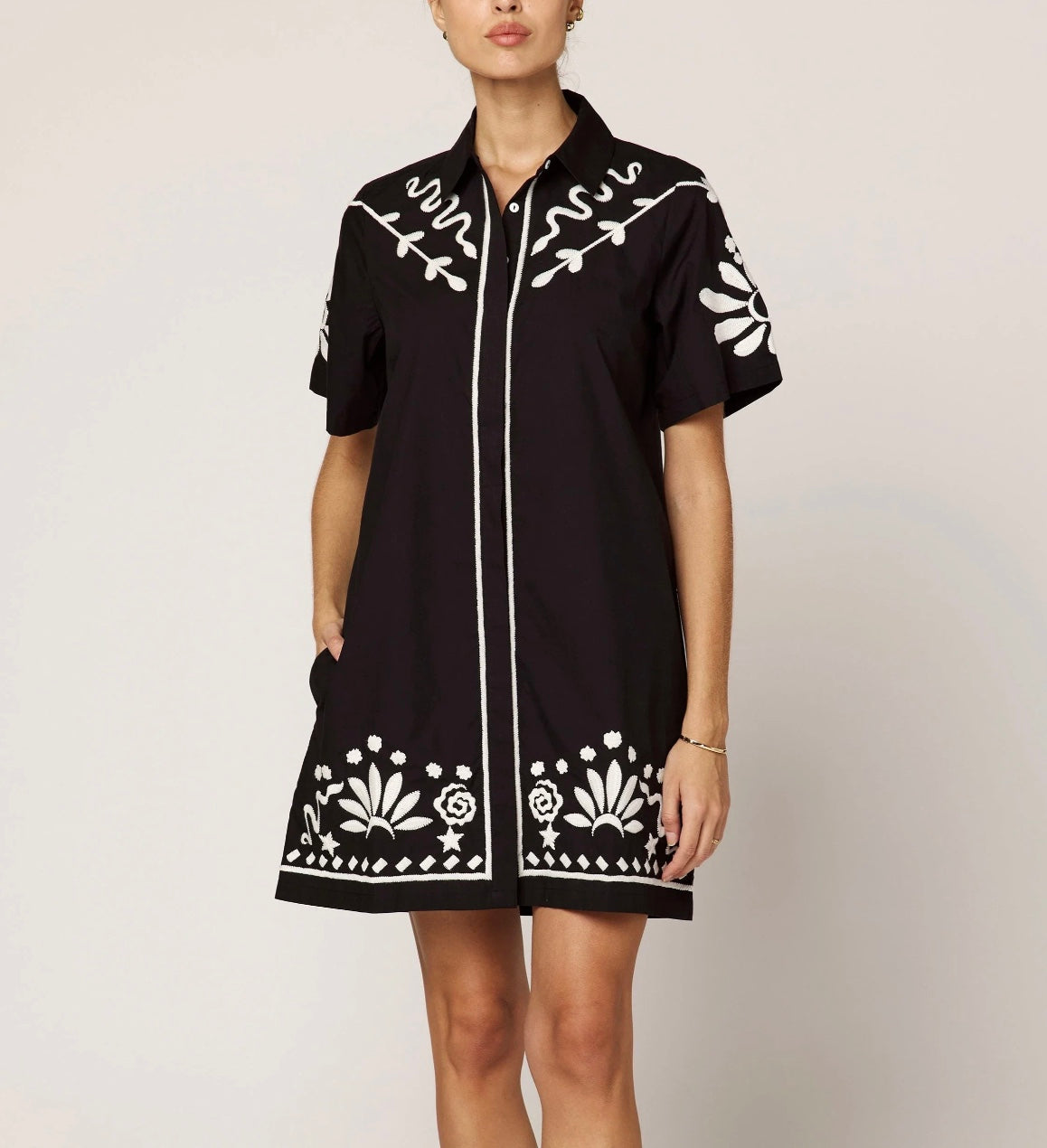 The Riya Mini Dress features a relaxed, button-down silhouette with short sleeves